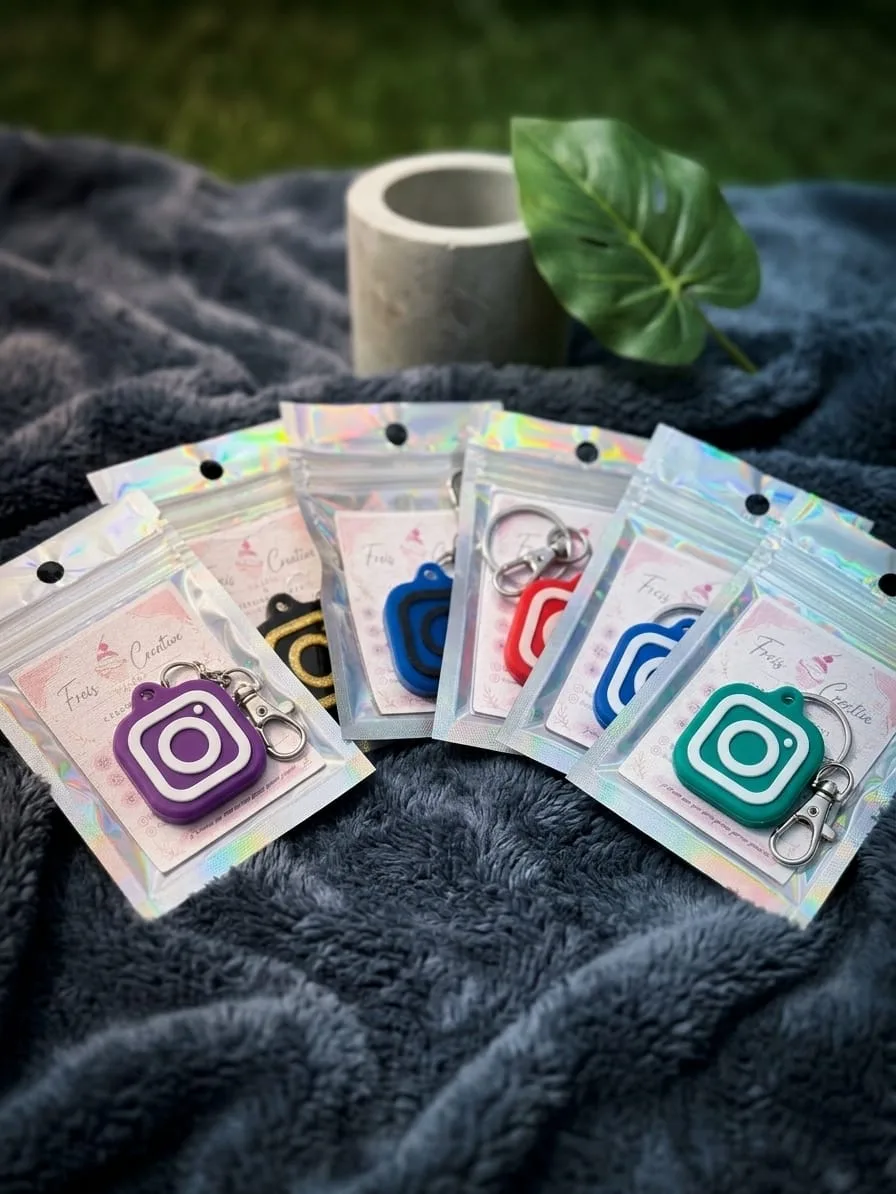 Llaveros con forma del icono de Instagram en varios colores, cada uno en su bolsa individual